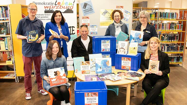 Von den vier antirassistische Bücherkisten sind (von links) überzeugt: Sebastian Haas, Eva Greber (sitzend, beide vom Bündnis für Demokratie und Zivilcourage, Christine Blum-Köhler (Leiterin Fachabteilung Integration Stadt Würzburg), Integrationsbegleiter Lucas Wejda (Sozialreferat), Martha Maucher (Leiterin Stadtbücherei Würzburg), Angelika Riedel (Kinderbücherei) und Elena Enzmann (Interkommunales Präventionsnetzwerk Radikalisierung, Sozialreferat).