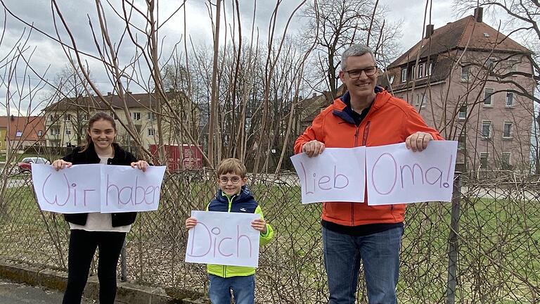 Vor dem Marienstift in Schweinfurt halten Charlotte, Peter und Chris Neckermann Schilder hoch. Die Nachricht ist für Oma Anita gedacht. Ein Stück Nähe in Zeiten der wegen des Coronavirus nötigen Distanz. Unter ihr leidet mancher Bewohner in den Senioreneinrichtungen, die inzwischen alle für Besucher geschlossen sind.