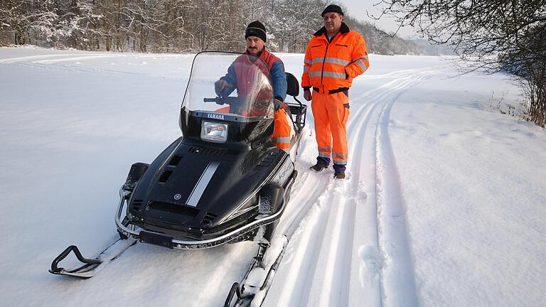 Zwei Männer im Schnee: Karl-Heinz Käppner (links) und Karl Volland vom Iphöfer Bauhof im Jahr 2010 beim Loipenspuren mit dem Motorschlitten.