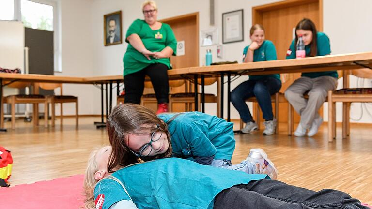 Erste Hilfe von klein auf: Die achtjährige Selina hört, ob ihre Freundin Sophie noch atmet. Danach bringt sie Sophie in die stabile Seitenlage.