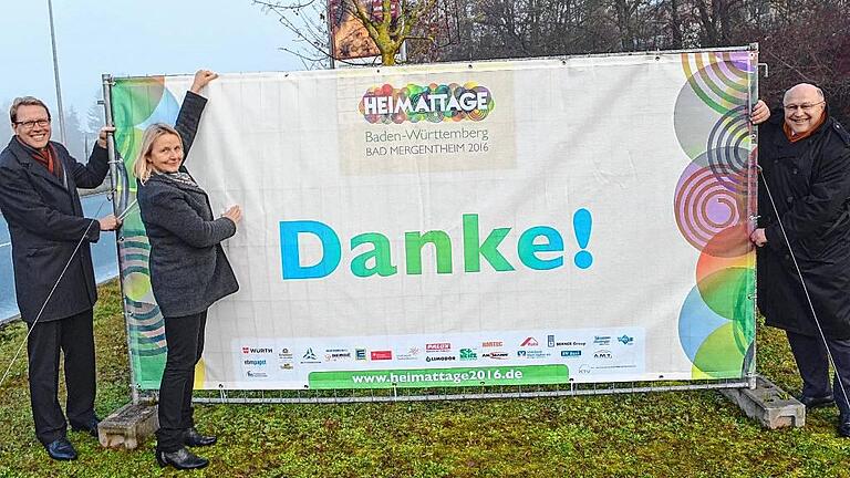 Mit großen Bannern sagt Bad Mergentheim dieser Tage &bdquo;Danke&ldquo; für ein beeindruckendes Heimattage-Jahr. Von links: Verkehrsdirektor Kersten Hahn, die Heimattage-Verantwortliche Sabine Mangold und Oberbürgermeister Udo Glatthaar.