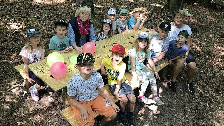 Nachwuchs wie auch Betreuerinnen fühlen sich auf dem neuen Mobiliar im Kindergartenwald sichtlich wohl.