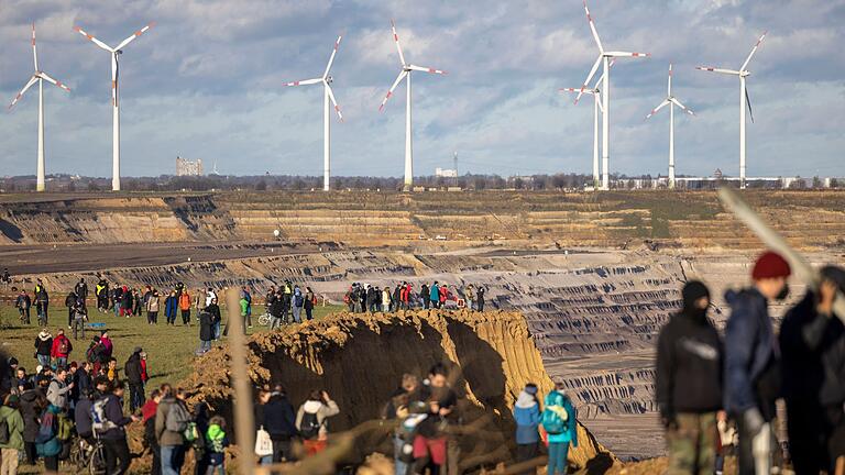 Nordrhein-Westfalen - Besucher stehen direkt an der Kante des Tagebaus Garzweiler II in Lützerath. Nordrhein-Westfalen - Besucher stehen direkt an der Kante des Tagebaus Garzweiler II in Lützerath.