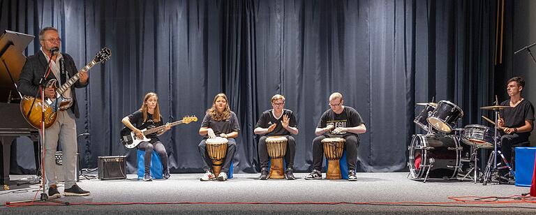 Schulleiter Philipp Arnold und eine Musikgruppe der 8. Klasse füllen die Aula mit Rhythmus. Schulleiter Philipp Arnold und eine Musikgruppe der 8. Klasse füllen die Aula mit Rhythmus.