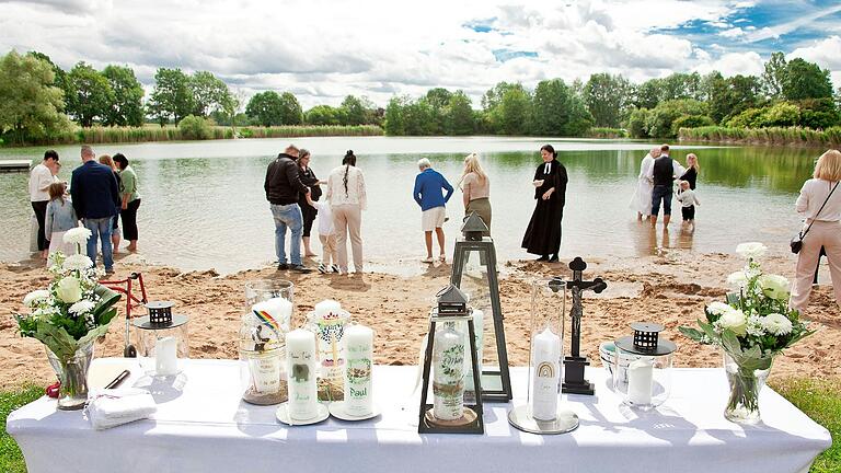 Auf dem Bild von links: Diakonin Cornelia Dennerlein, Pfarrerin Beate Hofmann-Landgraf und Pfarrer Lutz Mertten taufen die Kinder. Pfarrerin Julia Mucha lädt zur Tauferinnerung ein. Im Vordergrund der Altar mit den Taufkerzen der Taufkinder.