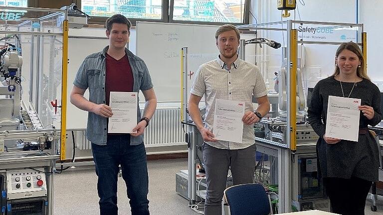 Stolz präsentieren (von links) Sven Eckert, Lukas Tatusch und Liska Schönmeyer ihr Robotik-Zertifikat von ABB Robotics.