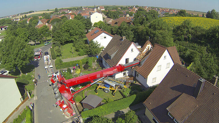 Kran stürzt auf Wohnhaus       -  Als er einen Baukran in Bibergau von der Straße auf ein Wohngrundstück heben sollte, ist am Freitagvormittag ein 60-Tonnen-Autokran umgekippt und auf das Wohnhaus gestürzt.