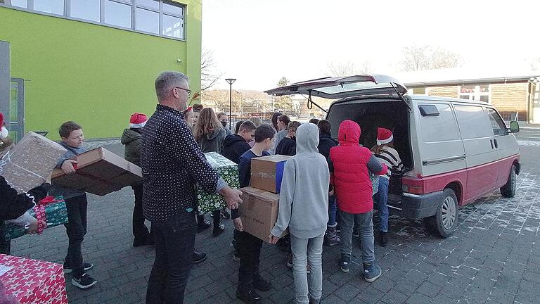 Fleißige Hände helfen beim Einladen der Weihnachtspakete.