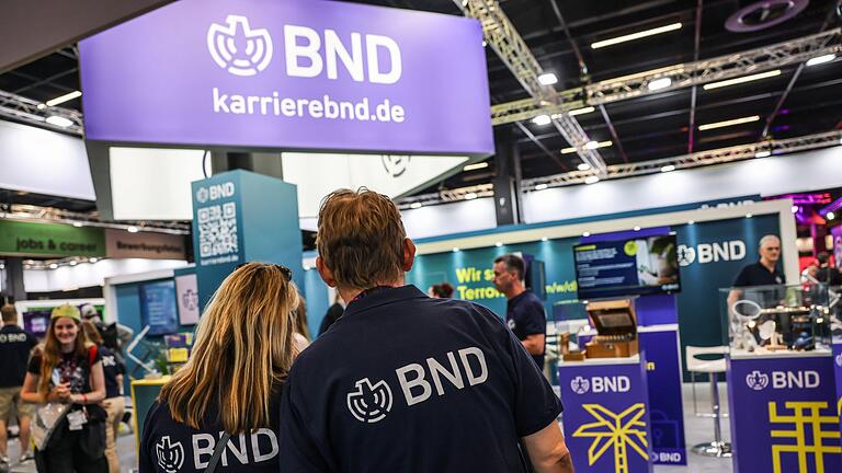 BND-Stand bei Gamescom       -  Mitarbeiter des BND stehen am Gamescom-Messestand ihrer Behörde. Die Bundesbehörde zählt circa 6.500 Beschäftigte.