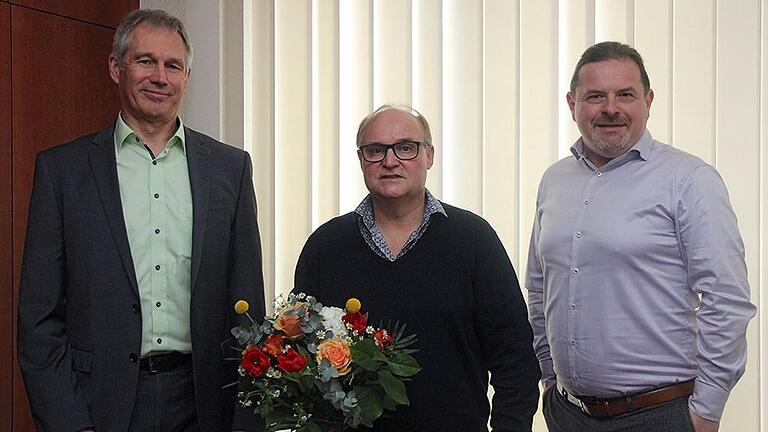 Jürgen Zips, Stellvertreter des Geschäftsführers und Direktor der Deutschen Rentenversicherung Nordbayern (links), und&nbsp;Holger Brach, Vertreter des Personalrats (rechts), gratulierten dem Jubilar Klaus Scherer.