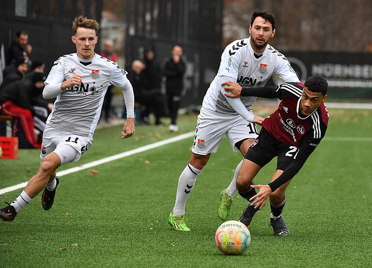 Leonard Langhans (links) und Timo Pitter (Mitte) vom TSV Aubstadt) überlaufen Nathaniel Brown vom 1. FC Nürnberg II.