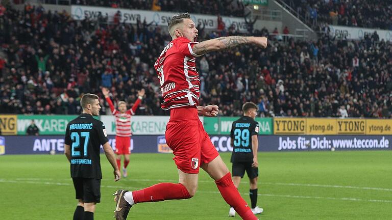 FC Augsburg - TSG 1899 Hoffenheim       -  Der FCA-Kapitän Jeffrey Gouweleeuw jubelt nach dem 1:0. Fredrik Jensen hatte die Vorlage des Niederländers verwertet.