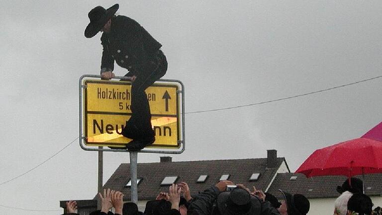 Zimmermann Neubrunn       -  Übers Ortschild: Niko Kettner am Tag seiner Rückkehr von der Walz.