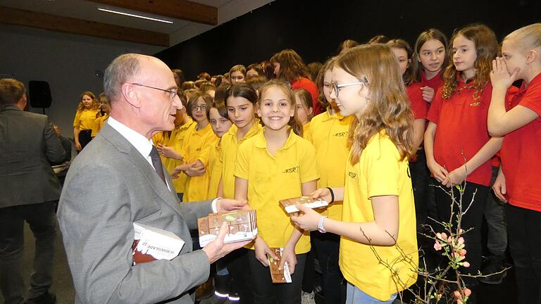 Landrat Wilhelm Schneider überraschte die Schüler mit einer Tafel Fairtrade-Schokolade für jeden aktiven Sänger.