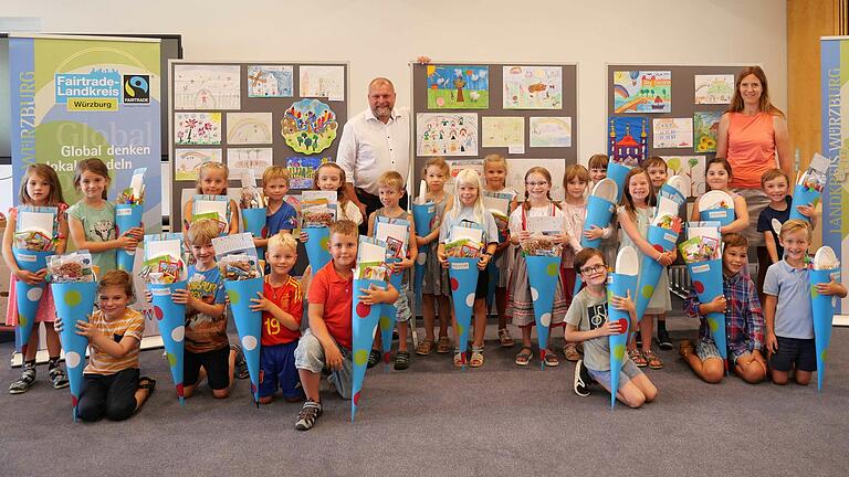 Bei der Preisverleihung des Malwettbewerbs „Meine bunte Heimat“ holten sich die Gewinnerinnen und Gewinner Schultüten voll bepackt mit Süßem und Nützlichem für den Schulstart ab. Mit ihnen freuten sich Daniela Schuster, Leiterin des Fachbereichs Schule bei der Stadt Würzburg (hinten rechts) und Landrat Thomas Eberth (hinten Mitte).