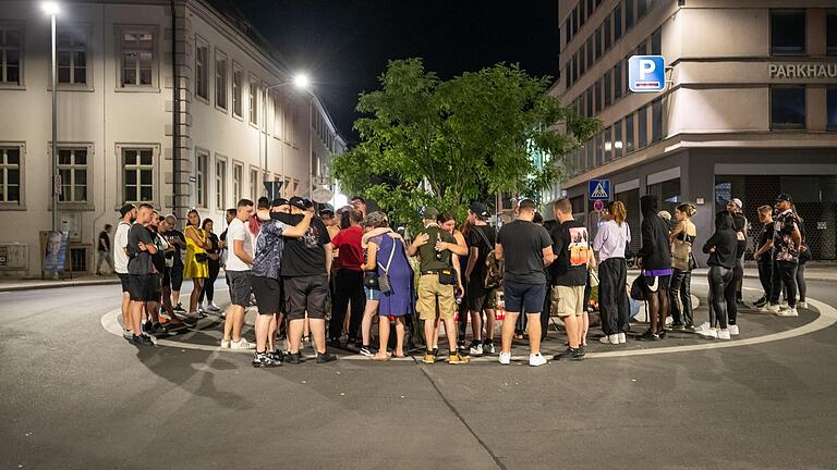 Trauer am Kreisverkehr: Am Sonntagabend versammeln sich mehrere Menschen in der Würzburger Innenstadt, um Kerzen und Blumen am Tatort niederzulegen.