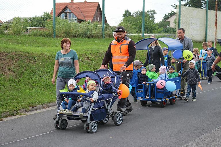 Ein Hauch von Faschingsumzug: Angeführt vom Kindergarten-Bulldog führte der Weg über den Pfingstgraben und die Jahnstraße zur neuen Kita bei der Grundschule. Gesichert durch die Feuerwehr, winkten an den Straßenrändern Eltern und Großeltern oder schlossen sich kurzerhand der Schar an. Ein Hauch von Faschingsumzug: Angeführt vom Kindergarten-Bulldog führte der Weg über den Pfingstgraben und die Jahnstraße zur neuen Kita bei der Grundschule. Gesichert durch die Feuerwehr, winkten an den Straßenrändern Eltern und Großeltern oder schlossen sich kurzerhand der Schar an.
