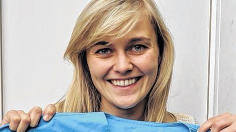 Jeanette Gumpp zeigt den Arztkittel mit dem Logo des Projektes der Uni Witten/Herdecke mit Myanmar.