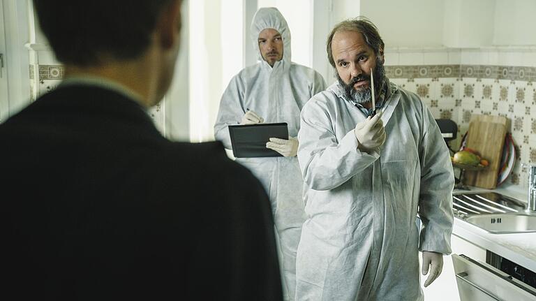 Szene aus dem sechsten Franken-'Tatort': Der Leiter der Spurensicherung Michael Schatz (Matthias Egersdörfer) mit seinem Kollegen (Danny Rosness) in der Küche des Opfers. Er zeigt Kriminalhauptkommissar Felix Voss (Fabian Hinrichs) die Mordwaffe.