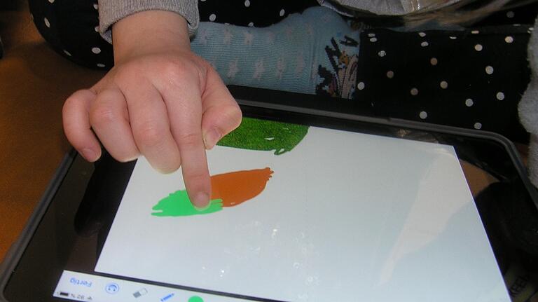 Lucys Lieblingstier ist der Hase. Für ihn malt sie eine Karotte auf das Tablet.