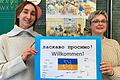 Schulleiterin Marietta Menz (links) und Klassenlehrerin Barbara Wieber mit dem Willkommensschild, das Viertklässler für ihren neuen Klassenkameraden aus der Ukraine gebastelt haben.