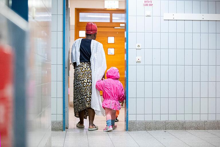 Eine Mutter und ihr Kind auf dem Weg ins Kinderhaus im Ankerzentrum für Unterfranken. Eine Mutter und ihr Kind auf dem Weg ins Kinderhaus im Ankerzentrum für Unterfranken. 
