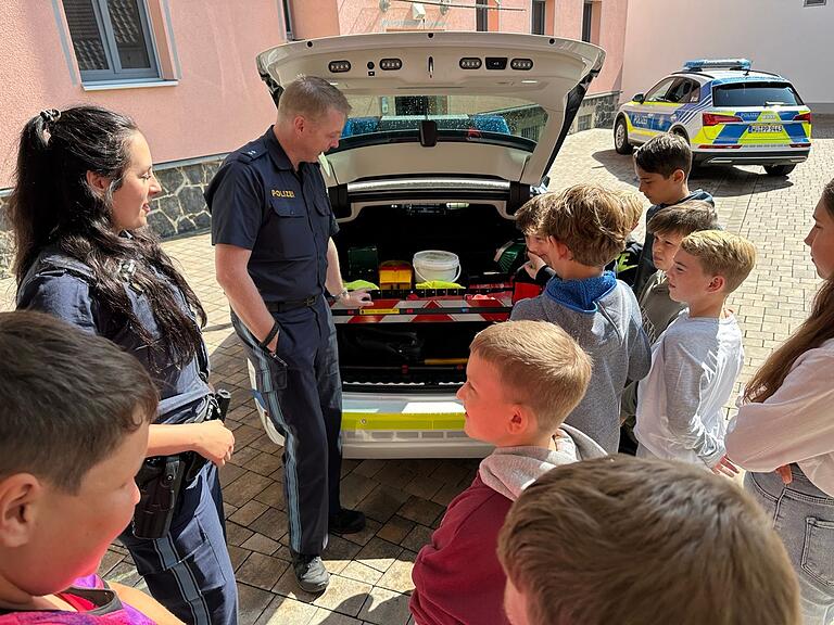 Vasiliki Filippaki und Jochen Gerhäuser erklären ein Polizeiauto und zeigen auch, was an Ausrüstung mitgeführt wird.