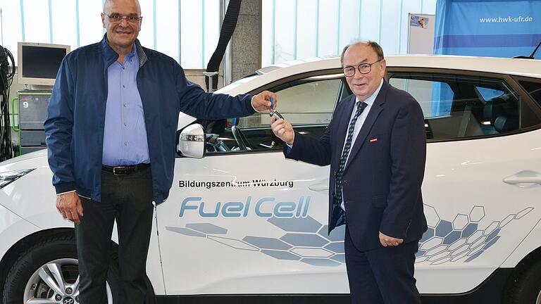 Jens Schürer übergibt Walter Heußlein, Präsident der Handwerkskammer für Unterfranken, den Schlüssel eines Hyundai ix35 Fuel Cell. Dieses Fahrzeug wird im Bildungszentrum Würzburg der Handwerkskammer für die zukunftsgerichtete Aus- und Weiterbildung im Kfz-Bereich eingesetzt.