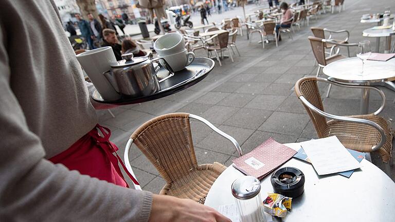 Eine Servicekraft in der Gastronomie räumt einen Tisch ab.jpg       -  Minijob in der Gastronomie: Junge Menschen, die Bürgergeld beziehen, haben mittlerweile mehr von ihrem Gehalt.