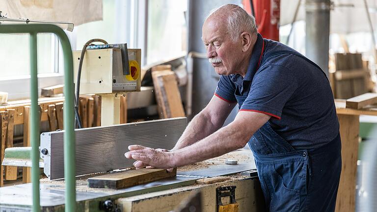 Seniorchef Karl Aßmann bei der Holzverarbeitung. Der 81-jährige Büttner packt in der Werkstatt noch immer mit an.&nbsp;&nbsp;