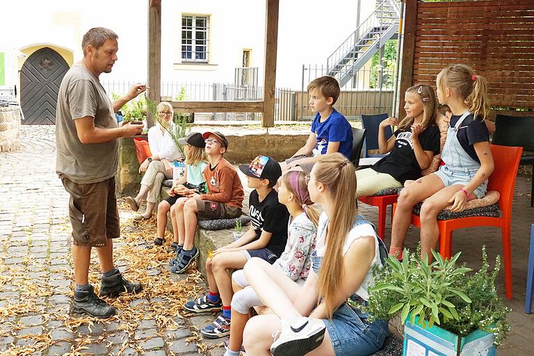 Stadtgärtner André Ditterich zeigte den Kindern die Pflanzen, die in die Einkaufswagen gepflanzt werden sollten, darunter Tomaten, Rucola oder Zitronenmelisse.