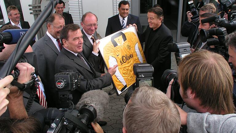 Der damalige Bundeskanzler Gerhard Schröder (links) erhielt 2003 beim Besuch des Textilunternehmens s.Oliver in Rottendorf bei Würzburg von Firmeninhaber Bernd Freier ein Fußballtrikot überreicht.