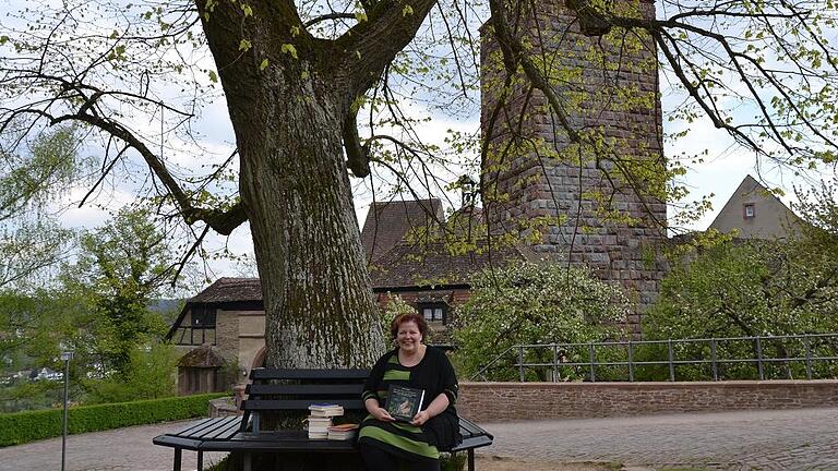 Anja Schmidt, die neue Betreiberin der Burgbücherei Bergrothenfels, unter dem Lindenbaum auf der Wiese vor dem Buchladen.