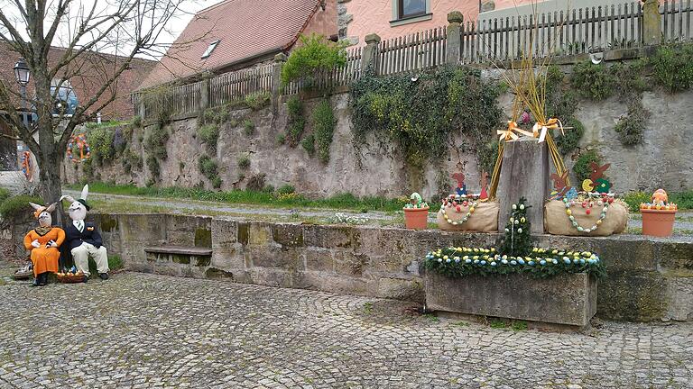 Osterbrunnen samt Osterhasen-Ehepaar.