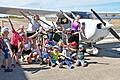 Die Kinder freuen sich über einen spannenden Tag am Flugplatz Schenkenturm. Die drei Betreuerinnen Laura (kniend), Fabienne und Karo (hintere Reihe) von der Sportferienfreizeit Sanderrasen hatten mit ihrer Gruppe einen riesigen Spaß beim Kinderfliegen.