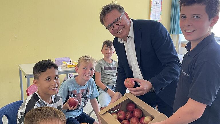 Schulleiter Stefan Wolbert verteilt gemeinsam mit Franz Böhm die Äpfel an glückliche Fünftklässler.