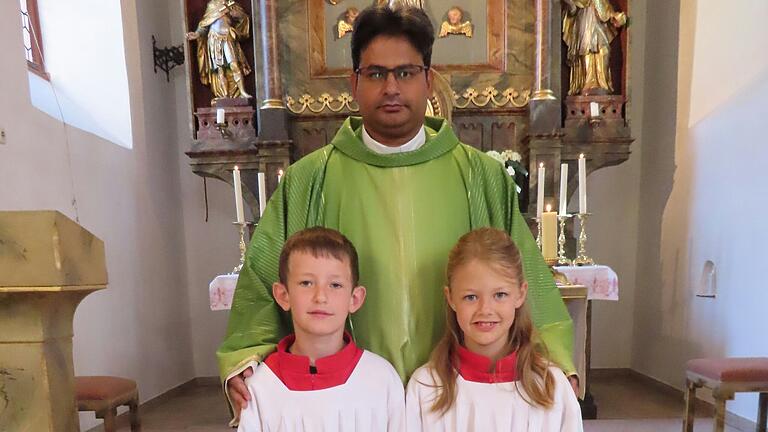 Die beiden neuen Ministranten Lina Müller und Anton Brückner mit Pater David Susai.