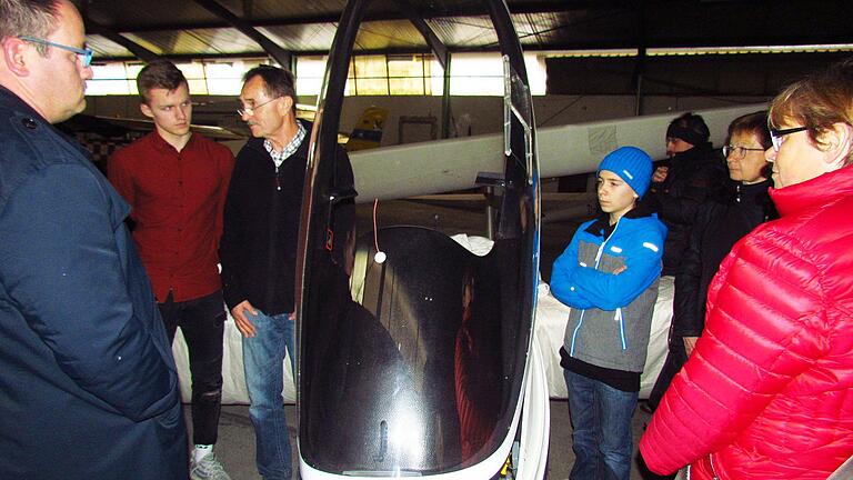 Die Besucher des Vhs-Infotages auf dem Flugplatz in Altfeld hörten gut zu, was ihnen Jürgen Denk (3. v. l.) im Hangar über die technischen Feinheiten eines Segelflugzeuges zu sagen hatte.