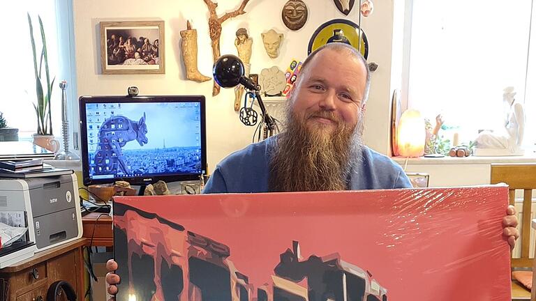 Thomas Seuberling mit einem seiner Werke. Im Hintergrund ist das wichtigste Utensil seiner Kunst erkennbar: der Computer. Darüber: Skurrile Fundstücke, die die unverwechselbare Dekoration in seiner Wohnung ausmachen. Foto: Susanne Will       -  Thomas Seuberling mit einem seiner Werke. Im Hintergrund ist das wichtigste Utensil seiner Kunst erkennbar: der Computer. Darüber: Skurrile Fundstücke, die die unverwechselbare Dekoration in seiner Wohnung ausmachen. Foto: Susanne Will