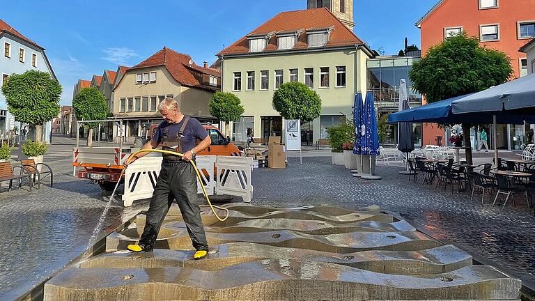 Früh am Morgen ist Michael Zirkelbach in Bad Neustadt unterwegs, um den Springbrunnen am Marktplatz mit dem Hochdruckreiniger zu reinigen.