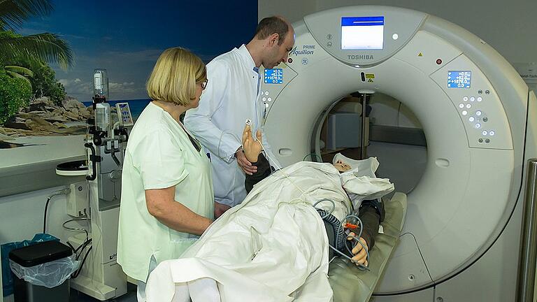 Neurologe Dr. Peter Kraft und eine Schwester mit einem Schlaganfall-Patienten in der Computertomografie.