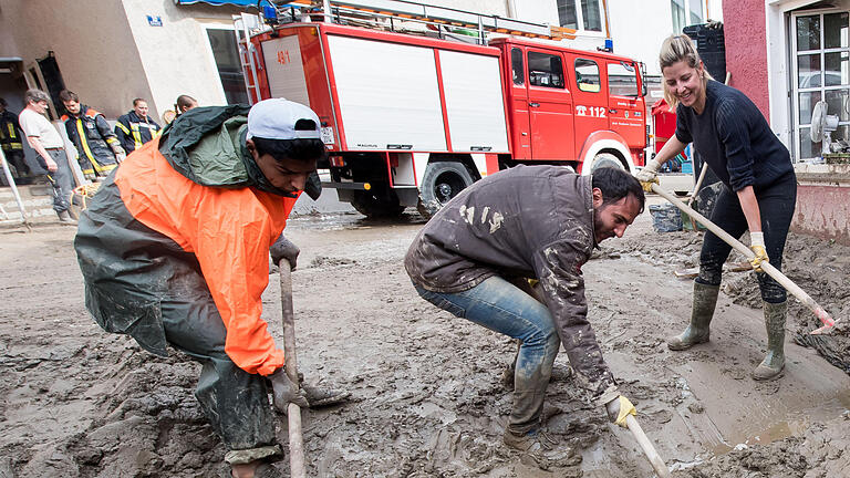 Aufräumarbeiten nach Überschwemmungen       -  Nach der Hochwasser-Katastrophe in mehreren Städten in Niederbayern helfen viele Menschen bei den Aufräumarbeiten mit. Mindestens sieben Menschenleben hat die Flutwelle gefordert.