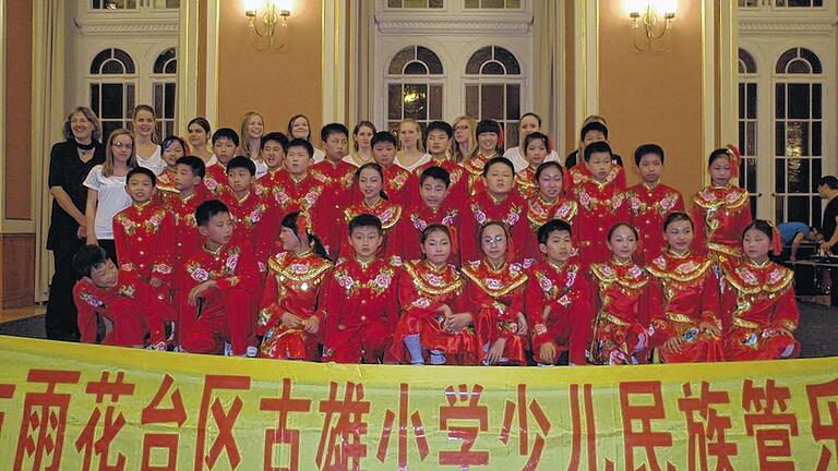 Die Mädchen des Jugendchors Mellrichstadt zusammen mit dem chinesischen Orchester (links im Bild: Chorleiterin Marianne Klemm).