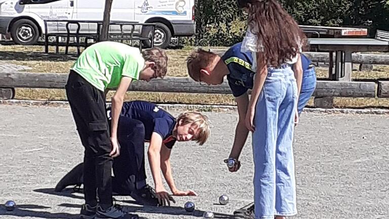 Eine Schülerin und drei Schüler beim Boule-Turnier am Ende der Französischtage.