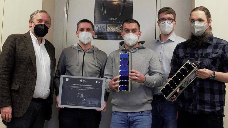 Freuen sich, dass drei ihrer Satelliten mit einer deutschen Trägerrakete ins All gelangen sollen: (von links) ZfT-Vorstand Klaus Schilling, Julian Scharnagl (Leiter Raumfahrt), Projektleiter Ilham Mammadov, Daniel Eck (Geschäftsführer ZfT) und Systemingenieur Alexander Kleinschrodt mit Exemplaren der Kleinsatelliten.