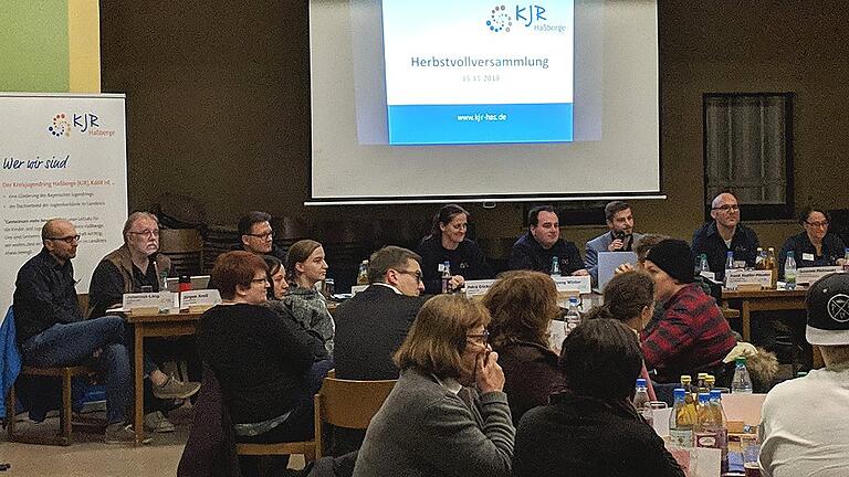 Thomas Wagenhäuser (auf dem Podium Dritter von rechts) begrüßt die Delegierten und Gäste der KJR-Herbstvollversammlung.