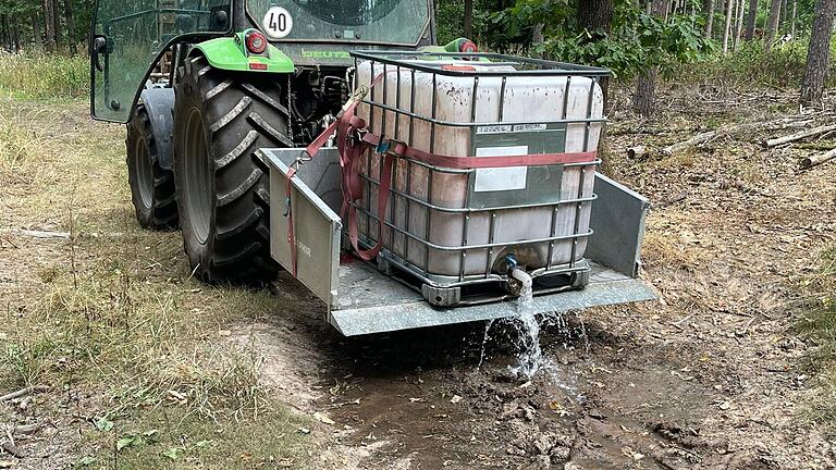 Mit Wasserfässern werden im Sulzdorfer Wald Erdkuhlen aufgefüllt