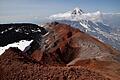 Auf dem Vulkan Avacinskij gibt es schwarze und rote Lava. Im Hintergrund der 3458 Meter hohe Vulkan Korjakskij mit den typischen Ufo-Wolken.&nbsp;