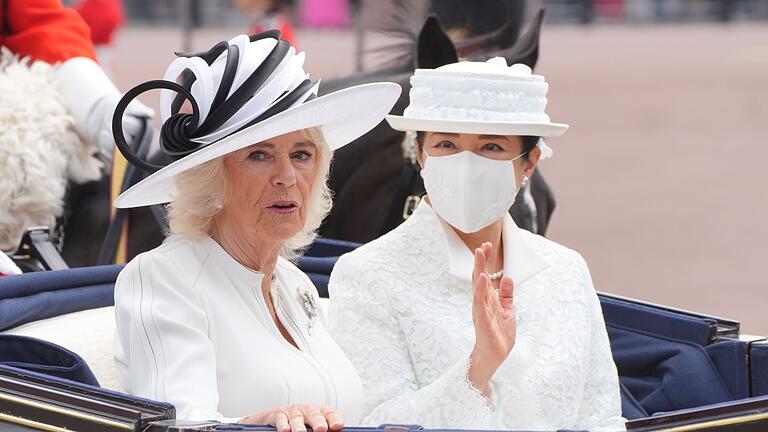 Japanisches Kaiserpaar zu Besuch in Großbritannien       -  Die britische Königin Camilla (l) und die japanische Kaiserin Masako fahren in einer offenen Kutsche beim Staatsbesuch in Großbritannien.