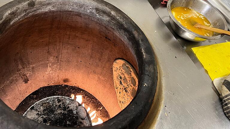 Taj Curryhaus in Bad Kissingen       -  An den heißen Seitenwänden des Tandoor wird das Naanbrot gebacken.